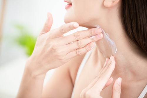 Young,Beauty,Woman,Applying,Cream,Or,Sunscreen,On,Her,Neck