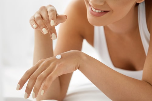 Woman,Hand,With,Cream.,Closeup,Portrait,Of,Beautiful,Happy,Girl