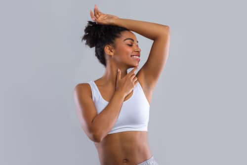 Happy,Black,Girl,Smelling,Her,Fresh,Armpit,Over,Grey,Background,
